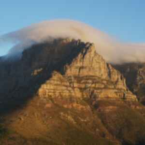 Table mountain at dusk with clouds rolling over the top