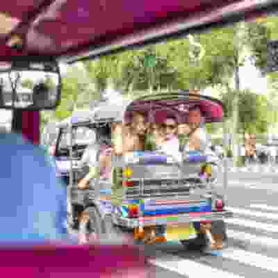 Travellers riding in a tuk tuk in Bangkok.