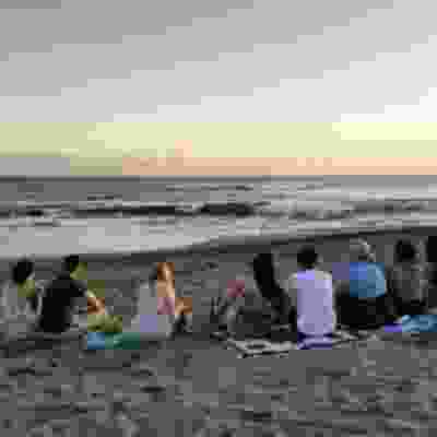 Group of travellers watching the sunset over Seminyak beach.