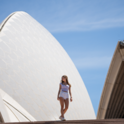 Girl walking in front of the Sydney Opera House.