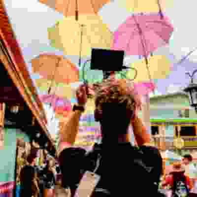 Male traveller taking a photo of floating umbrella walkway in Cartegena.
