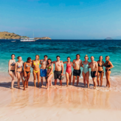 Group photo of travellers on the beach shore in Lombok.