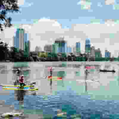 View of the city of Austin from across the lake where people are kayaking.