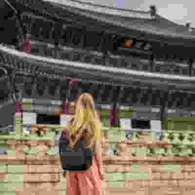 Blonde traveller looking at the Gyeongbokgung palace, Seoul. 