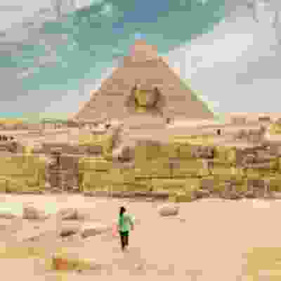 Male traveller walking towards the Pyramids of Giza.