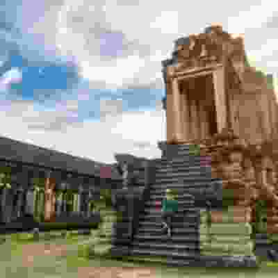 Blonde women standing on steps whilst exploring Angkor Wat.