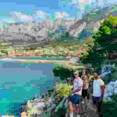 Group of travellers smiling in front of the mountains in Mljet national park.