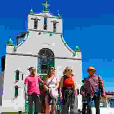 Travellers standing in front of a traditional church in Oaxaca.