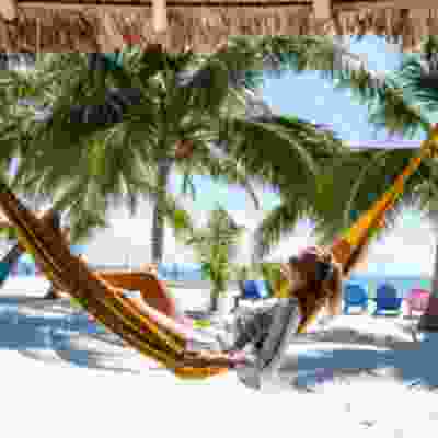 Women traveller relaxing in a hammock on Playa Del Carmen beach.